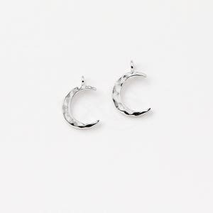 May include: Two silver crescent moon charms with a hammered texture.