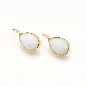 Peut inclure: Une paire de boucles d'oreilles en forme de goutte d'or avec des accents de pierres précieuses blanches.