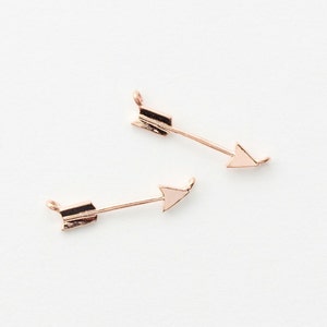 May include: Two gold arrow charms with a loop at the top for attaching to jewelry or other crafts.
