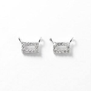 May include: Two silver rectangle pendant charms with a clear crystal border.