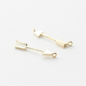 Könnte beinhalten: Zwei goldene Pfeil-Anhänger mit einer Öse oben zum Anbringen an Schmuck oder andere Bastelarbeiten.