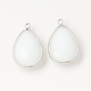 May include: Two white teardrop-shaped glass pendants with silver metal frames and loops for hanging.