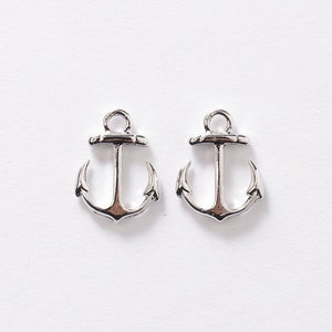 May include: Two silver anchor charms, each with a loop at the top for attaching to jewelry or other crafts.