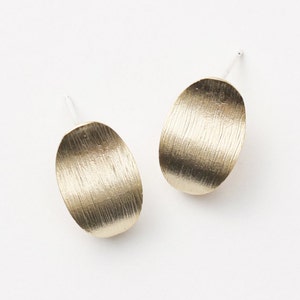 Puede incluir: Un par de pendientes ovalados de oro con acabado cepillado.