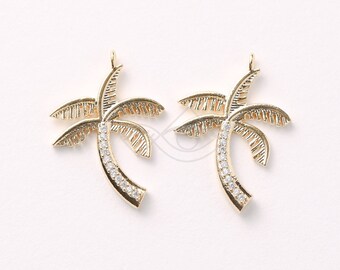 May include: Two gold palm tree charms with clear crystal accents. The charms are detailed with a textured palm tree design and are perfect for adding a tropical touch to jewelry.