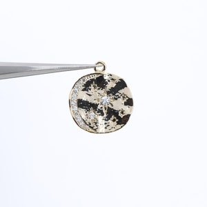 Op de afbeelding: Gouden hanger met een halve maan en een ster met heldere strass steentjes. De hanger heeft een gehamerde textuur.