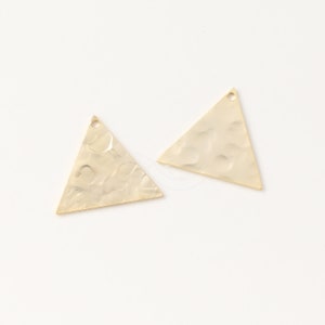 May include: Two gold-toned triangle-shaped metal charms with a hammered texture. Each charm has a small hole at the top for attaching to jewelry or other crafts.