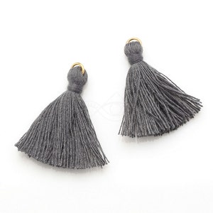 May include: Two gray tassel ornaments with gold rings. The tassels are made of soft, thin yarn and are approximately 2 inches long.