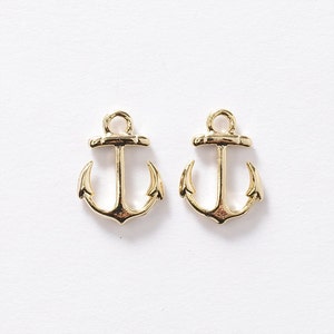May include: Two gold-colored metal anchor charms. The anchors have a classic design with a loop at the top for attaching to jewelry or other crafts.