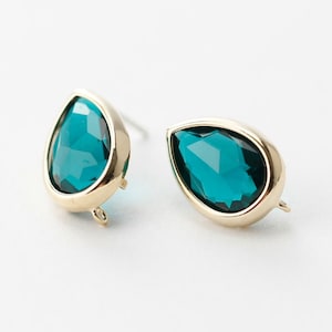 May include: A pair of gold teardrop earrings with a dark teal gemstone.