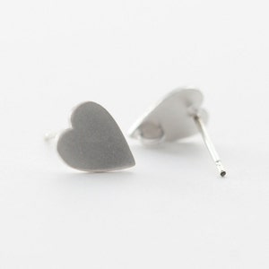 Puede incluir: Un par de pendientes de plata en forma de corazón. Los pendientes son simples y elegantes, y serían un gran regalo para alguien especial.