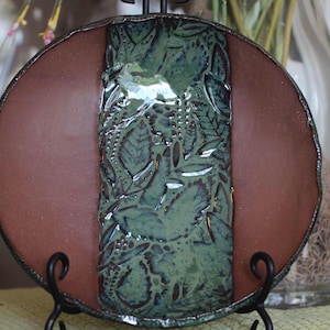 May include: A set of three ceramic mugs with a speckled, matte finish. The mugs are in shades of cream, light brown, and dark brown. Each mug has a simple, minimalist design and a rounded handle. The mugs are likely for coffee or tea.