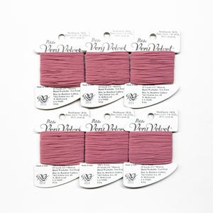 May include: Six spools of dusty rose pink embroidery floss, each labeled "Petite Very Velvet" with details about the floss, including the brand, length, and care instructions.