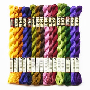 May include: A collection of 15 DMC embroidery floss spools in various colors, including yellow, blue, green, brown, pink, and purple. Each spool is labeled with the DMC color number.