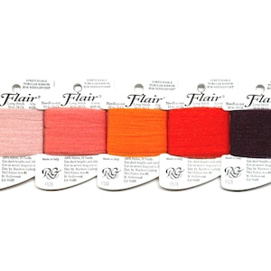 May include: Five spools of Flair needlepoint tubular ribbon in shades of pink, coral, orange, red, and brown. Each spool is labeled with the Flair logo and product information. The ribbon is made of nylon and is 10 yards in length.