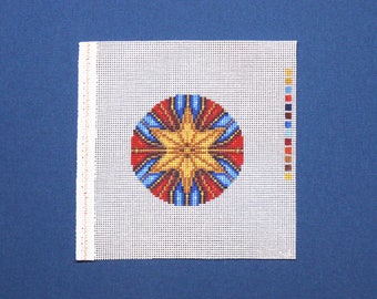 May include: A white canvas with a colorful geometric design in the center. The design features a star with red, blue, and yellow colors.