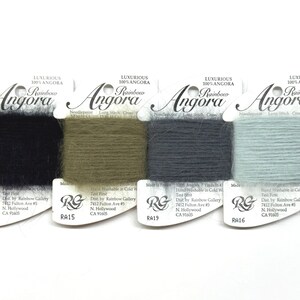 May include: Four spools of luxurious 100% Angora yarn in black, olive green, grey, and light blue. Each spool is labeled with the "Angora" brand name and product information.