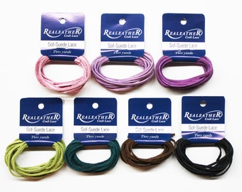 May include: Eight spools of soft suede lace, each with a label that reads "REALEATHER Craft Lace Sof-Suede Lace Two yards". The spools are arranged in two rows of four, with the colors pink, purple, green, teal, brown, and black.