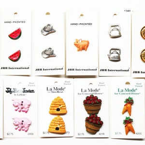 May include: Assortment of hand-painted buttons featuring various farm and garden themes.  The buttons are on white cards with the text "Hand-Painted" and the brand name "JHB International" or "La Mode".