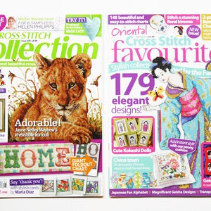 May include: Two cross stitch magazines with colorful covers. The left magazine features a lion cub and the text "Cross Stitch Collection". The right magazine features a woman in a kimono and the text "Oriental Cross Stitch Favourites".