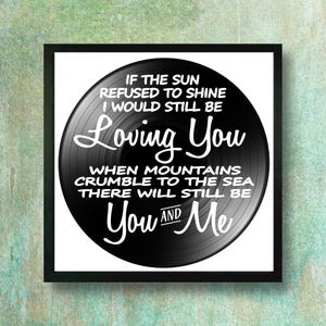 May include: A framed print featuring a black and white design resembling a vinyl record. The text on the record reads "If the sun refused to shine I would still be Loving You... You and Me."
