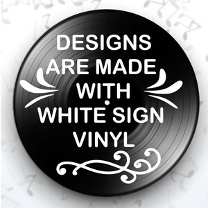 K&ouml;nnte beinhalten: Eine schwarze Schallplatte mit wei&szlig;em Text, der lautet: "DESIGNS ARE MADE WITH WHITE SIGN VINYL." Dekorative wei&szlig;e Verzierungen befinden sich auf der Platte. Der Hintergrund ist wei&szlig; mit Noten.