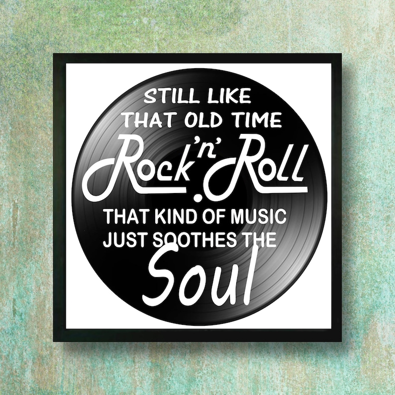 A Vinyl Record in a black metal frame. The record has white text that reads 'Still Like That Old Time Rock n' Roll. That Kind of Music Just Soothes the Soul.'