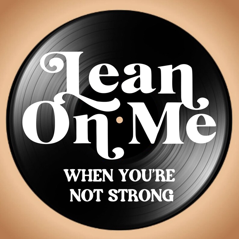 May include: A black vinyl record with the words "Lean On Me" in white, stylized lettering. Below, the text reads "When You're Not Strong". The record is set against a tan background.