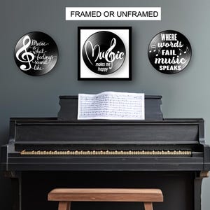 May include: A black piano with sheet music on the stand, and three framed or unframed wall art pieces. The art pieces are black with white text and musical notes. The text on the art pieces reads: "Music is what feelings sound like", "Music makes me happy", and "Where words fail music speaks".