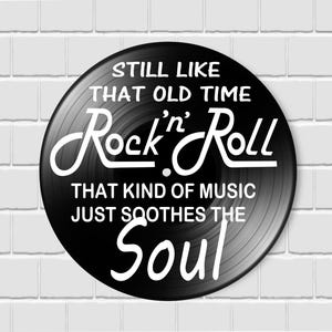 K&ouml;nnte beinhalten: Eine schwarze Schallplatte mit wei&szlig;em Text: "STILL LIKE THAT OLD TIME Rock'n'Roll THAT KIND OF MUSIC JUST SOOTHES THE Soul". Die Platte ist vor einer wei&szlig;en Backsteinmauer platziert.