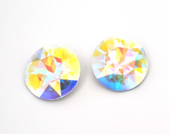 May include: Two iridescent round crystal-like buttons with a yellow, blue, and green color scheme.