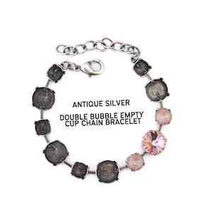 May include: Antique silver double bubble empty cup chain bracelet. The bracelet features a chain of dark gray, round, cup-shaped links interspersed with light pink and peach-colored crystals. The text "ANTIQUE SILVER DOUBLE BUBBLE EMPTY CUP CHAIN BRACELET" is visible.