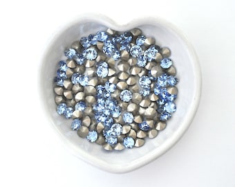 May include: A heart-shaped dish filled with light blue and silver rhinestones.