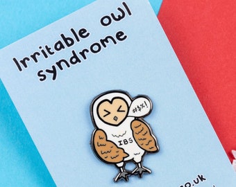 May include: White enamel pin with a cartoon illustration of an owl with a speech bubble that says "#$%!" and the text "IBS" on its chest. The pin is on a blue card with the text "Irritable owl syndrome" and "www.innabox.co.uk".