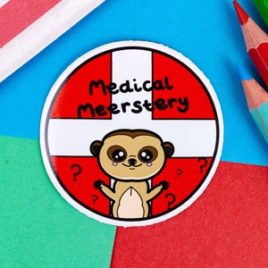 A circular sticker with white and red first aid cross as the background with a cute meerkat at the bottom with big eyes and pink cheeks and has its arms open wide. Across the top in black text reads medical meerstery.