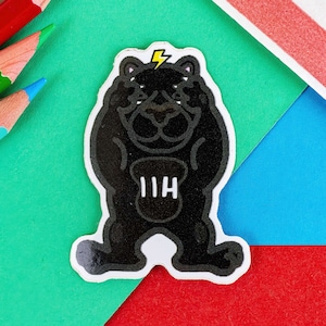 May include: Black and white sticker of a cartoon bear wearing a lightning bolt on its head. The bear is holding a weight with the letters "IIH" on it.
