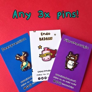 Three Innabox enamel pins shown on backing card on a red background. Choose from any three pins. Enamel pins designed to raise awareness for chronic illnesses