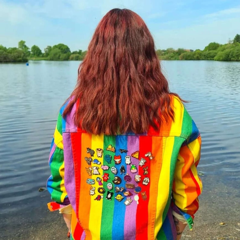 Nikky, innabox owner, wearing a rainbow denim jacket full of innabox enamel pins raising awareness for hidden disabilities and invisible illnesses.