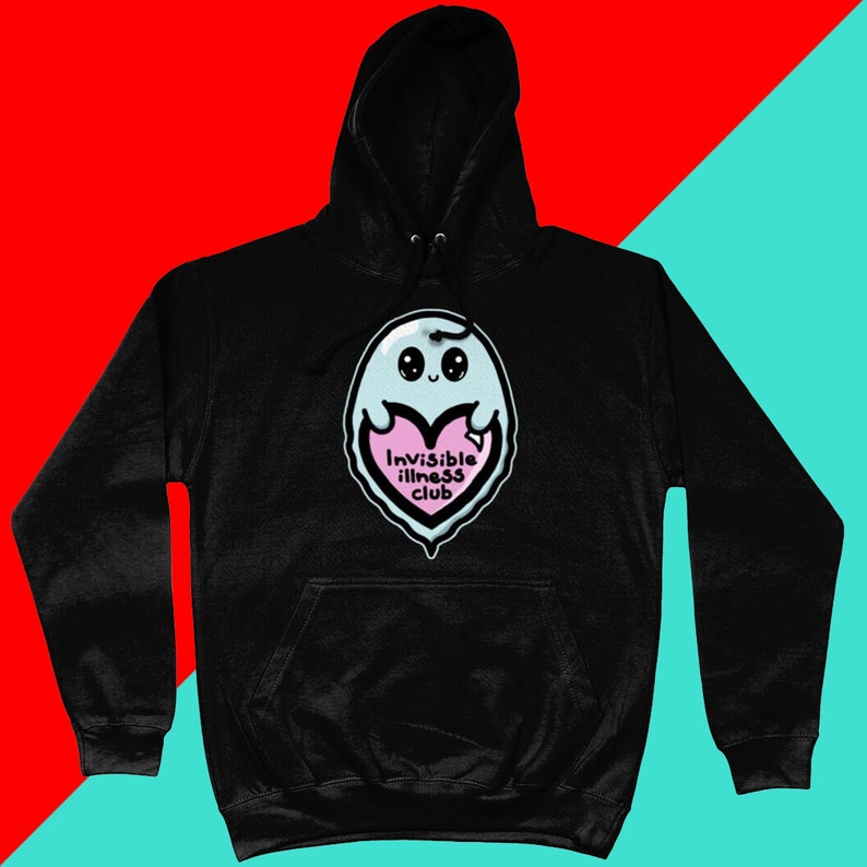 Invisible Illness Club Black Hoodie on a red & blue background. It has a pastel blue smiling ghost holding up a pink heart with text reading invisible illness club. It has a front pocket & drawstring hood. Raising awareness for hidden disabilites.