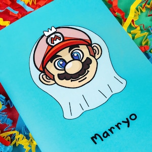 Marryo - Mario Engagement Wedding Card on red, blue & green card with crinkle card confetti. Blue a6 congratulations card of a smiling nintendo mario character head wearing a white bridal wedding veil, underneath him is black text reading Marryo.