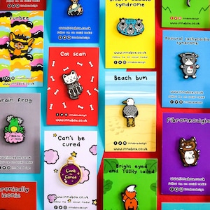 An array of Innabox enamel pins shown on backing card on a red background. Choose from any three pins. Enamel pins designed to raise awareness for chronic illnesses