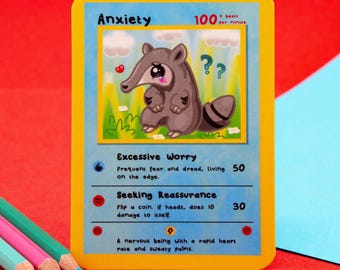 Könnte beinhalten: Eine gelbe Karte mit dem Wort "Angst" oben, mit einem Cartoon-Ameisenbären mit Fragezeichen und einem Herzen. Die Karte enthält Text über übermäßige Sorgen und die Suche nach Bestätigung.