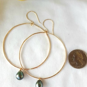 Shimmery soldered and hammered 14k gold-filled hoops with baroque style black Tahitian pearl drops. Hoops measure 2.25&quot; diameter