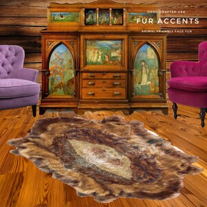 May include: A brown faux fur rug with a long pile, laid out on a wooden floor in front of an antique wooden cabinet with glass doors and drawers. The cabinet has a painted scene of people in a forest. The text "HAND CRAFTED USA FUR ACCENTS ANIMAL FRIENDLY FAUX FUR" is visible above the cabinet.