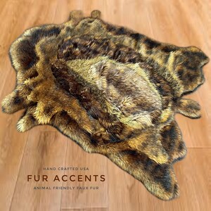 May include: A brown and black faux fur rug with a shaggy texture. The rug is hand-crafted in the USA and is animal-friendly. The text "FUR ACCENTS" and "ANIMAL FRIENDLY FAUX FUR" is printed on the rug.