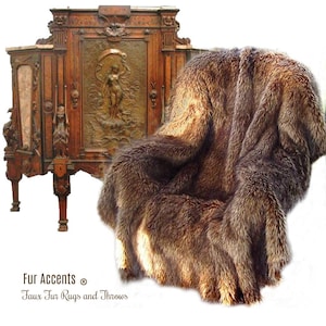 May include: A brown faux fur throw draped over a wooden chair. The throw is made of long, soft fibers and has a natural look. The chair is antique and has intricate carvings. The text "Fur Accents® Faux Fur Rugs and Throws" is visible at the bottom of the image.