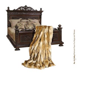 May include: A dark wood carved bed frame with a faux fur throw blanket in shades of brown and beige. The bed is made with a patterned bedspread and pillows.