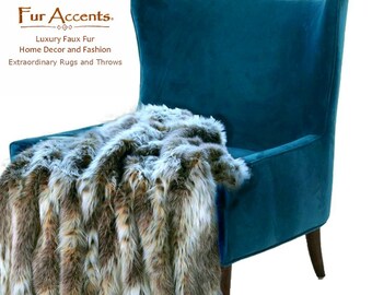 May include: A teal blue armchair with a faux fur throw blanket in brown, white, and gray. The throw blanket is made of long, soft fibers. The throw blanket is draped over the back and seat of the armchair. The armchair has a high back and a curved seat. The armchair is on a white background.
