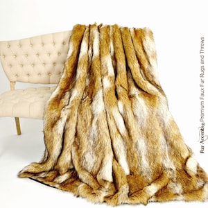 May include: A soft, brown and white faux fur throw blanket draped over a white tufted bench. The blanket has a long, shaggy pile and is perfect for adding warmth and texture to any room.