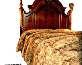 May include: A luxurious faux fur bedspread in a brown and beige colour scheme. The bedspread is made of soft, plush fur and is perfect for adding a touch of elegance to any bedroom. The bedspread is shown on a wooden bed frame with a carved headboard.